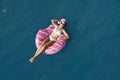 Young woman wearing Santa hat and bikini with inflatable ring in sea. Christmas vacation Royalty Free Stock Photo