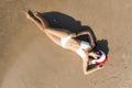 Young woman wearing Santa hat and bikini on beach, top view. Christmas vacation Royalty Free Stock Photo