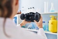 Young woman wearing scientist uniform holding virtual reality goggles at laboratory Royalty Free Stock Photo