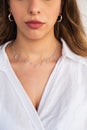 Young woman wearing a silver clear necklace and silver earrings