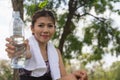 Young woman wearing sport wear giving drinking water bottle forward. sweaty thirsty, resting break time. Sport healthy girl. Royalty Free Stock Photo