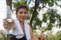 Young woman wearing sport wear giving drinking water bottle forward. sweaty thirsty, resting break time. Royalty Free Stock Photo