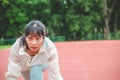 Young woman wearing sports clothes and ready to start running on the track in stadium, sport women