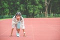 Young woman wearing sports clothes and ready to start running on the track in stadium, sport women