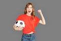 Freestyle. Woman in sports clothes studio standing isolated on grey with ball screaming excited supporting team Royalty Free Stock Photo