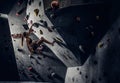 Young woman wearing sportswear practicing rock-climbing on a wall indoors Royalty Free Stock Photo