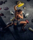 Young woman wearing sportswear practicing rock-climbing on a wall indoors Royalty Free Stock Photo