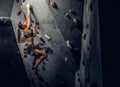 Young woman wearing sportswear practicing rock-climbing on a wall indoors Royalty Free Stock Photo