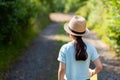 Young woman wearing a straw hat in the park. Back view Royalty Free Stock Photo