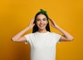 Young woman wearing stylish bandana on orange background Royalty Free Stock Photo