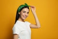 Young woman wearing stylish bandana on orange background, space for text Royalty Free Stock Photo