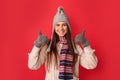 Freestyle. Young woman wearing scarf and hat standing isolated on red thumbs up looking camera cheerful Royalty Free Stock Photo