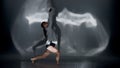 Young woman wearing a top, shorts and a shirt performing contemporary dance under the glare of the light in the studio