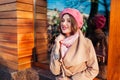 Young woman wearing trendy coat and beret outdoors. Spring female clothes and accessories. Fashion
