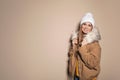 Young woman wearing warm clothes on color background, space for text. Ready for winter