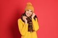 Young woman wearing warm sweater, scarf and hat on background. Winter season