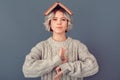 Young woman in a woolen sweater on grey wall winter concept meditating Royalty Free Stock Photo