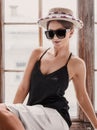 Young woman wearing white shorts, black top, hat and sunglasses Royalty Free Stock Photo