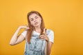 Young woman wearing white t-shirt, over orange background shows emotions Royalty Free Stock Photo