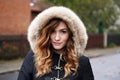 Young woman wearing winter coat with fake fur hood outdoors Royalty Free Stock Photo