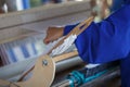 Young woman weaves a white cloth on a hand wood loom Royalty Free Stock Photo