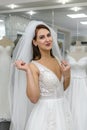 Young woman in wedding dress and veil in bridal shop Royalty Free Stock Photo