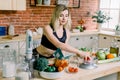 Young Woman weighs cherry tomatoes while Cooking salad in the kitchen. Healthy Food - Vegetable Salad. Diet. Dieting