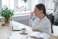 Young woman welcomes by raising her hand, the interviewee in online video chat.