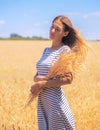 Young woman at the wheat field under the blue sky at the sunny day Royalty Free Stock Photo