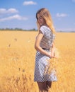 Young woman at the wheat field under the blue sky at the sunny day Royalty Free Stock Photo