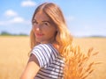 Young woman at the wheat field under the blue sky at the sunny day Royalty Free Stock Photo