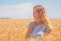 Young woman at the wheat field under the blue sky at the sunny day Royalty Free Stock Photo