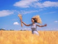 Young woman at the wheat field under the blue sky at the sunny day Royalty Free Stock Photo