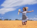 Young woman at the wheat field under the blue sky at the sunny day Royalty Free Stock Photo