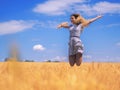 Young woman at the wheat field under the blue sky at the sunny d Royalty Free Stock Photo