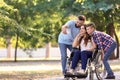 Young woman in wheelchair with her family taking selfie outdoors Royalty Free Stock Photo