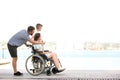 Young woman in wheelchair with her family walking outdoors Royalty Free Stock Photo