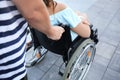 Young woman in wheelchair with her husband walking outdoors Royalty Free Stock Photo