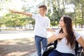 Young woman in wheelchair with her son walking outdoors Royalty Free Stock Photo