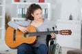 young woman on wheelchair playing guitar Royalty Free Stock Photo