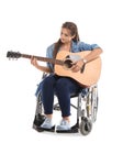 Young woman in wheelchair playing guitar on white background Royalty Free Stock Photo