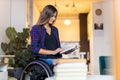 Woman in wheelchair reading a book at home