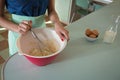 Young woman whisking mixture into bowl in the kitchen