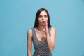 The young woman whispering a secret behind her hand over blue background