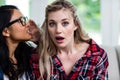 Young woman whispering to female friend Royalty Free Stock Photo