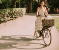 Young woman with white bichon frise dog in the basket of electric bike Royalty Free Stock Photo