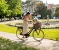 Young woman with white bichon frise dog in the basket of electric bike Royalty Free Stock Photo