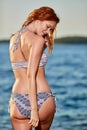 Young woman in white bikini on tropical beach looking at camera. Beautiful girl in swimwear with copy space. Summer Royalty Free Stock Photo