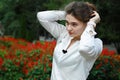 Young woman in white blouse fixes hair on his head with hairpin