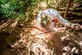 Young woman in white climbs the mountain on a rope. View from above. Tropical jungle. She is looking down